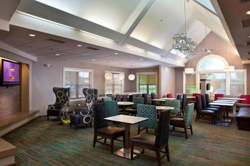 a restaurant with tables and chairs in a room at Residence Inn Baton Rouge South in Baton Rouge