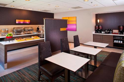 a restaurant with tables and chairs and a counter at Residence Inn Baton Rouge Siegen in Baton Rouge