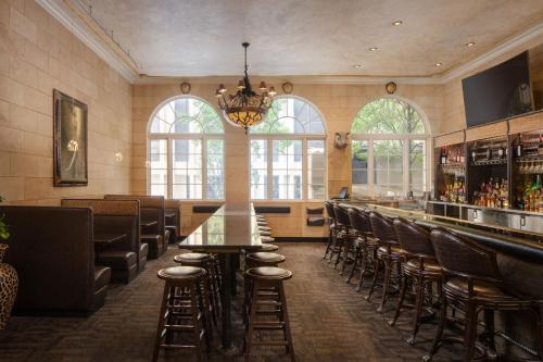 a restaurant with a bar with chairs and a chandelier at The Davenport Tower, Autograph Collection in Spokane
