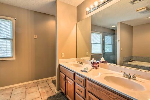 a bathroom with a sink and a large mirror at Charming Craftsman Home in Downtown Bartlesville! in Bartlesville