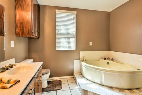 a bathroom with a tub and a toilet and a sink at Charming Craftsman Home in Downtown Bartlesville! in Bartlesville
