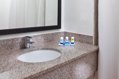 a bathroom sink with two toothbrushes and a mirror at Fairfield Inn & Suites Houston Hobby Airport in Houston