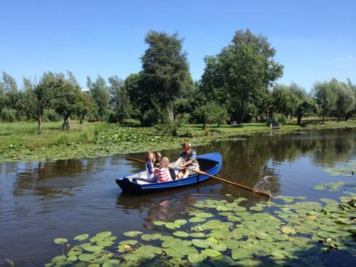 a group of people in a boat on a river at Droomgaerd in Vlist
