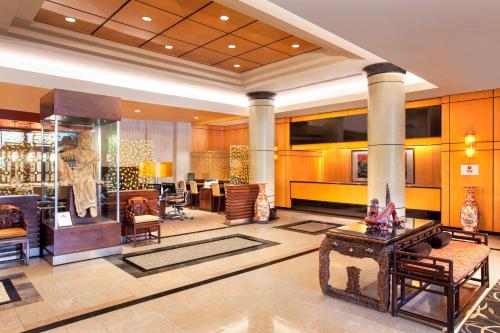 a lobby of a hotel with chairs and tables at Sheraton LaGuardia East Hotel in Queens