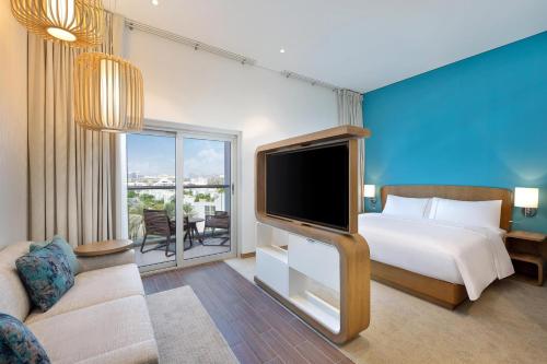 a bedroom with a bed and a flat screen tv at Element Dubai Airport in Dubai