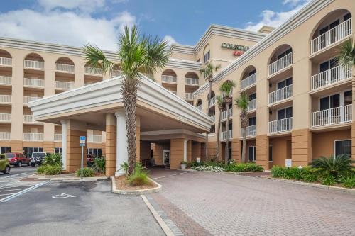 a palm tree in front of a building at Courtyard by Marriott Jacksonville Beach Oceanfront in Jacksonville Beach