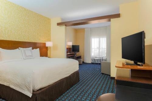 Fairfield Inn & Suites by Marriott Alexandria في أليكساندريا: غرفة فندقية بسرير وتلفزيون بشاشة مسطحة