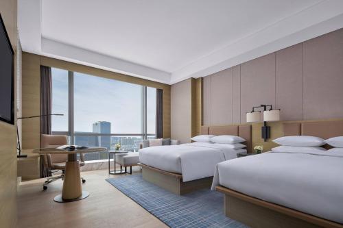 una camera d'albergo con due letti e una grande finestra di Baotou Marriott Hotel a Baotou