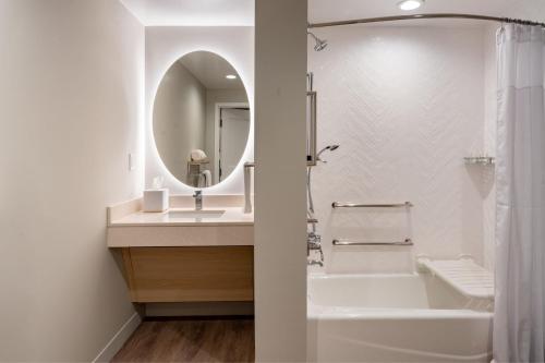 a bathroom with a tub and a sink and a mirror at TownePlace Suites by Marriott Ocala in Rolling Ranches
