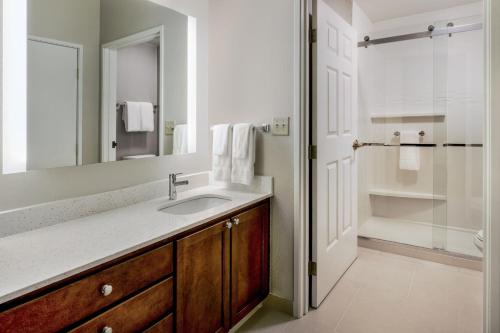 uma casa de banho com um lavatório e um chuveiro em Residence Inn by Marriott Chicago Oak Brook em Oak Brook