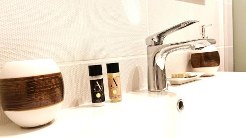 ein Waschbecken mit einem Wasserhahn und einigen Pflegeprodukten in der Unterkunft Suite Mirella in Neapel