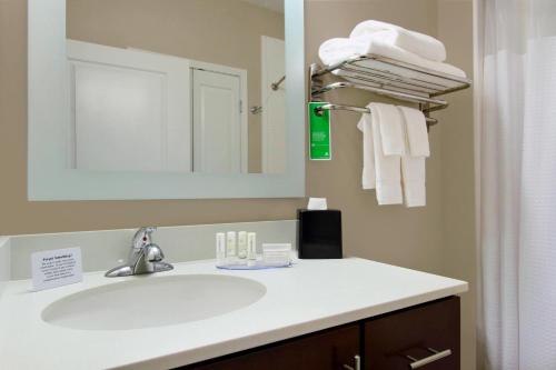 a bathroom with a sink and a mirror and towels at TownePlace Suites by Marriott New Orleans Harvey/West Bank in Harvey