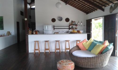 Una sala de estar con un sofá y una cocina. en Villa Lagosta no Abacaxi, en Córguinho