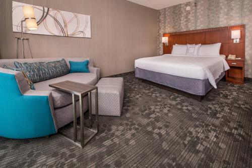 um quarto de hotel com uma cama e um sofá em Courtyard by Marriott Dulles Airport Chantilly em Chantilly