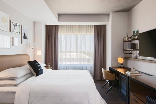 ein Hotelzimmer mit einem Bett, einem Schreibtisch und einem Fenster in der Unterkunft Renaissance Atlanta Airport Gateway Hotel in Atlanta