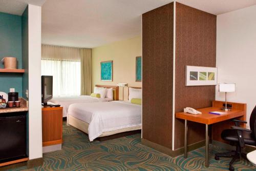 a hotel room with two beds and a desk at SpringHill Suites Boston Peabody in Peabody