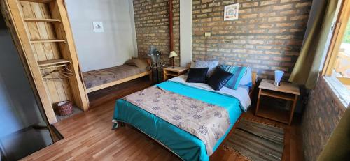 a bedroom with a bed and a brick wall at Rincón del Sur in El Bolsón