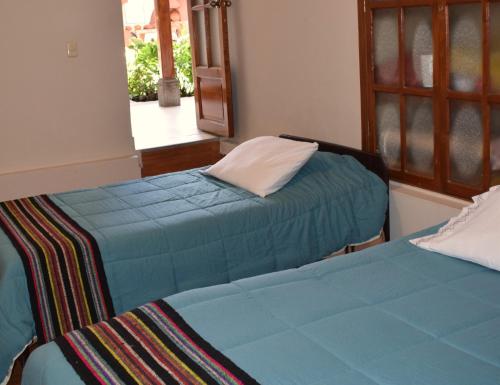 twee bedden naast elkaar in een kamer bij Casa Pablo in Cajamarca
