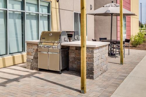 a grill and an umbrella on a brick patio at TownePlace Suites by Marriott Chicago Waukegan Gurnee in Waukegan