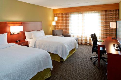 a hotel room with two beds and a desk at Courtyard by Marriott Ithaca Airport/University in Ithaca