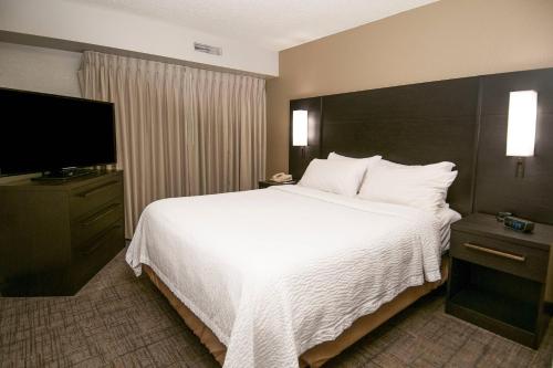 um quarto de hotel com uma cama grande e uma televisão de ecrã plano em Residence Inn by Marriott Springdale em Springdale