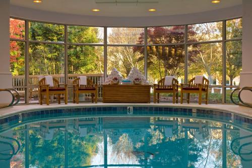 a swimming pool with chairs and a large window at Renaissance Charlotte SouthPark Hotel in Charlotte