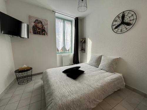 a bedroom with a bed and a clock on the wall at Au 15 - Charmant Studio hyper centre in Saint-Amand-Montrond