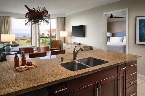 a kitchen with a sink and a living room at The Westin Ka'anapali Ocean Resort Villas North in Lahaina