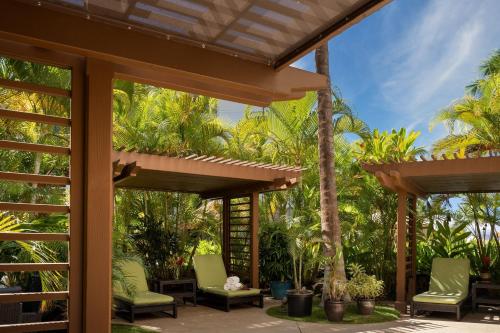 a patio with green chairs and palm trees at The Westin Ka'anapali Ocean Resort Villas North in Lahaina