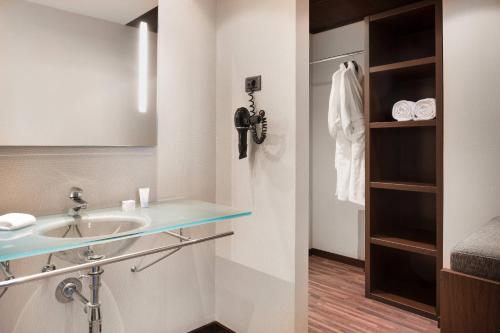 a bathroom with a sink and a telephone at AC Hotel Barcelona Fórum by Marriott in Barcelona