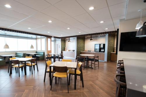 a restaurant with tables and chairs and a kitchen at Fairfield by Marriott Inn & Suites Kingsport in Kingsport