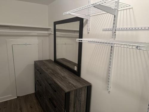 a closet with a mirror and a wooden dresser at 2 BR Loft 10 min from downtown in Nashville