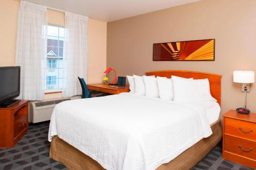 Habitación de hotel con cama y TV en TownePlace Suites Indianapolis Park 100, en Indianápolis