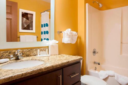 a bathroom with a sink and a toilet and a mirror at TownePlace Suites Indianapolis Park 100 in Indianapolis