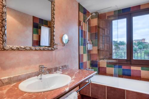 W łazience znajduje się umywalka, lustro i prysznic. w obiekcie AC Hotel Ciudad de Toledo by Marriott w mieście Toledo