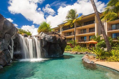 a waterfall in a pool in front of a hotel at Koloa Landing Resort at Po'ipu, Autograph Collection in Koloa