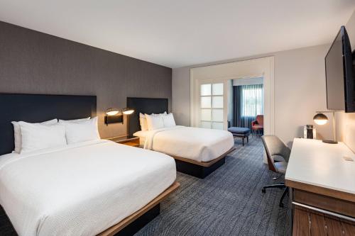 a hotel room with two beds and a television at Courtyard by Marriott Anaheim Resort/Convention Center in Anaheim