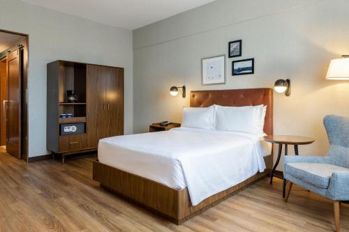 um quarto de hotel com uma cama e uma cadeira em Four Points by Sheraton Monterrey Airport em Monterrey