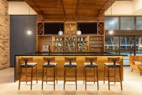 a bar with stools and a counter in a room at Four Points by Sheraton Monterrey Airport in Monterrey