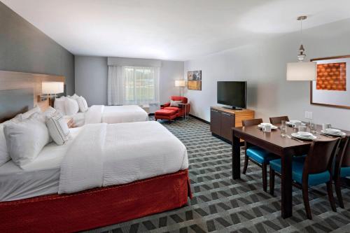 a hotel room with a bed and a dining room at TownePlace Suites by Marriott Baton Rouge Port Allen in Port Allen