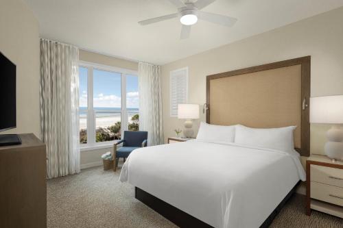a bedroom with a large white bed and a window at Marriott's Monarch at Sea Pines in Hilton Head Island