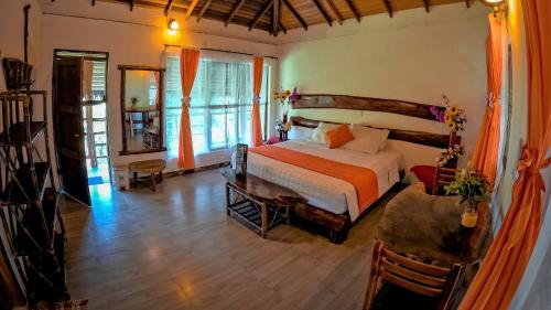 ein Schlafzimmer mit einem Bett und einem Schreibtisch in einem Zimmer in der Unterkunft Suchipakari Amazon Eco -Lodge & Jungle Reserve in Puerto Misahuallí
