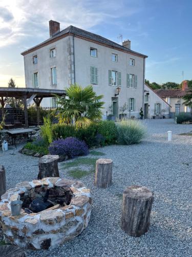 een tuin met een vuurplaats voor een gebouw bij Maison Hirondelles Gîtes in Mézières-sur-Issoire