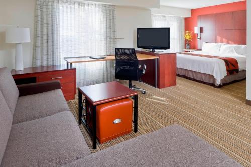 a hotel room with a bed and a desk with a television at Residence Inn Canton in North Canton