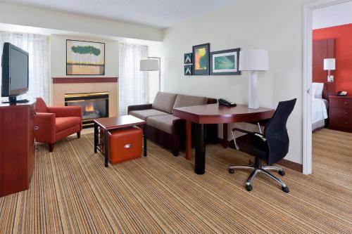 a hotel room with a desk and a couch and a room at Residence Inn Canton in North Canton