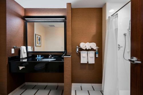 La salle de bains est pourvue d'un lavabo et d'une douche avec un miroir. dans l'établissement Fairfield Inn & Suites by Marriott Little Rock Benton, à Benton