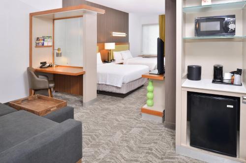 a hotel room with a bed and a living room at SpringHill Suites Ashburn Dulles North in Ashburn