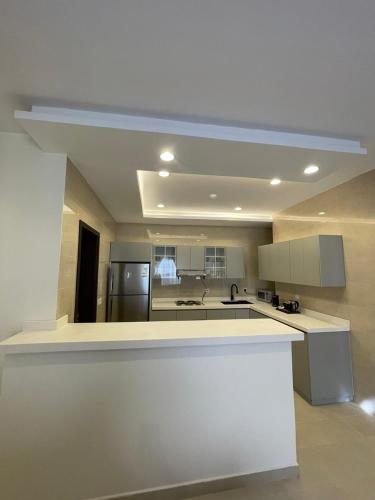 een keuken met een wit aanrecht en een koelkast bij MJ Private APARTMENT in Riyad