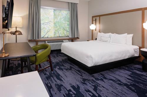 a hotel room with a bed and a desk and a window at Fairfield Inn & Suites by Marriott Queensbury Glens Falls/Lake George in Queensbury