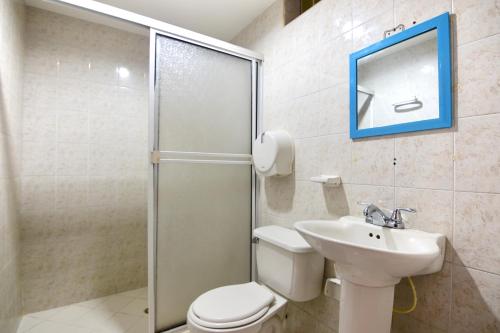 a bathroom with a shower and a toilet and a sink at Hotel Comercial in Sincelejo